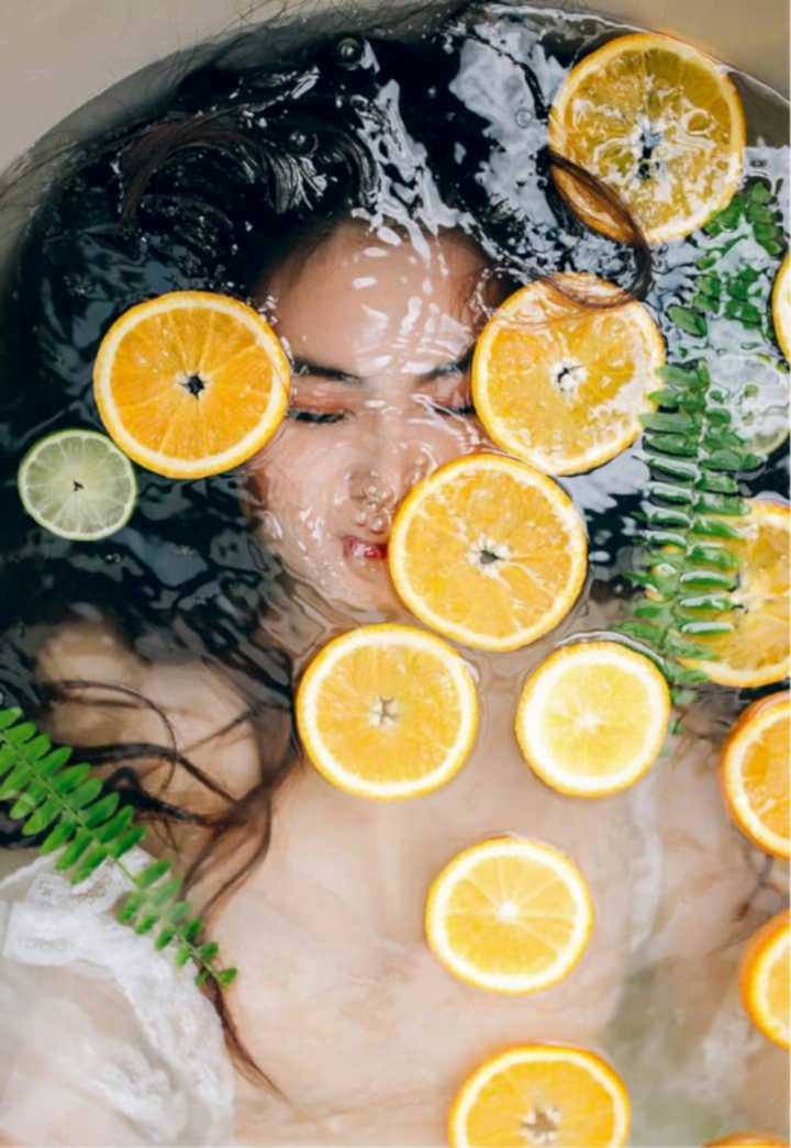 Woman Laying in Bath with Orange Slices Woman Laying in Bath with Orange Slices